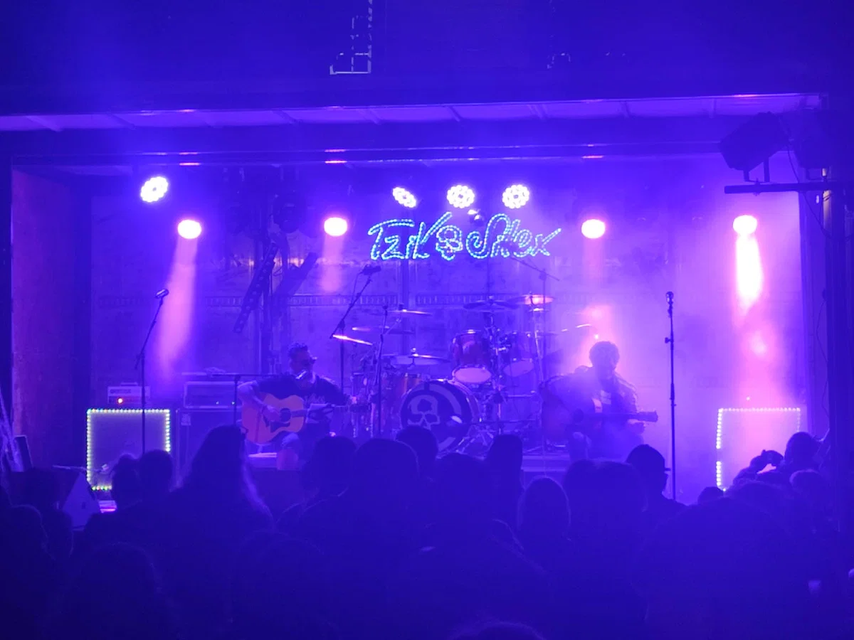 Concert en petite salle, enseigne néon et ambiance bleu profond